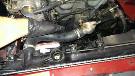 Disconnecting the upper radiator hose from the thermostat and block