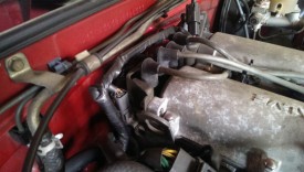 The coil pack is at the back of the engine, the spark plug wires connect to it