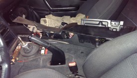 Lift the console up and then forward to clear the trunk/gas cap levers