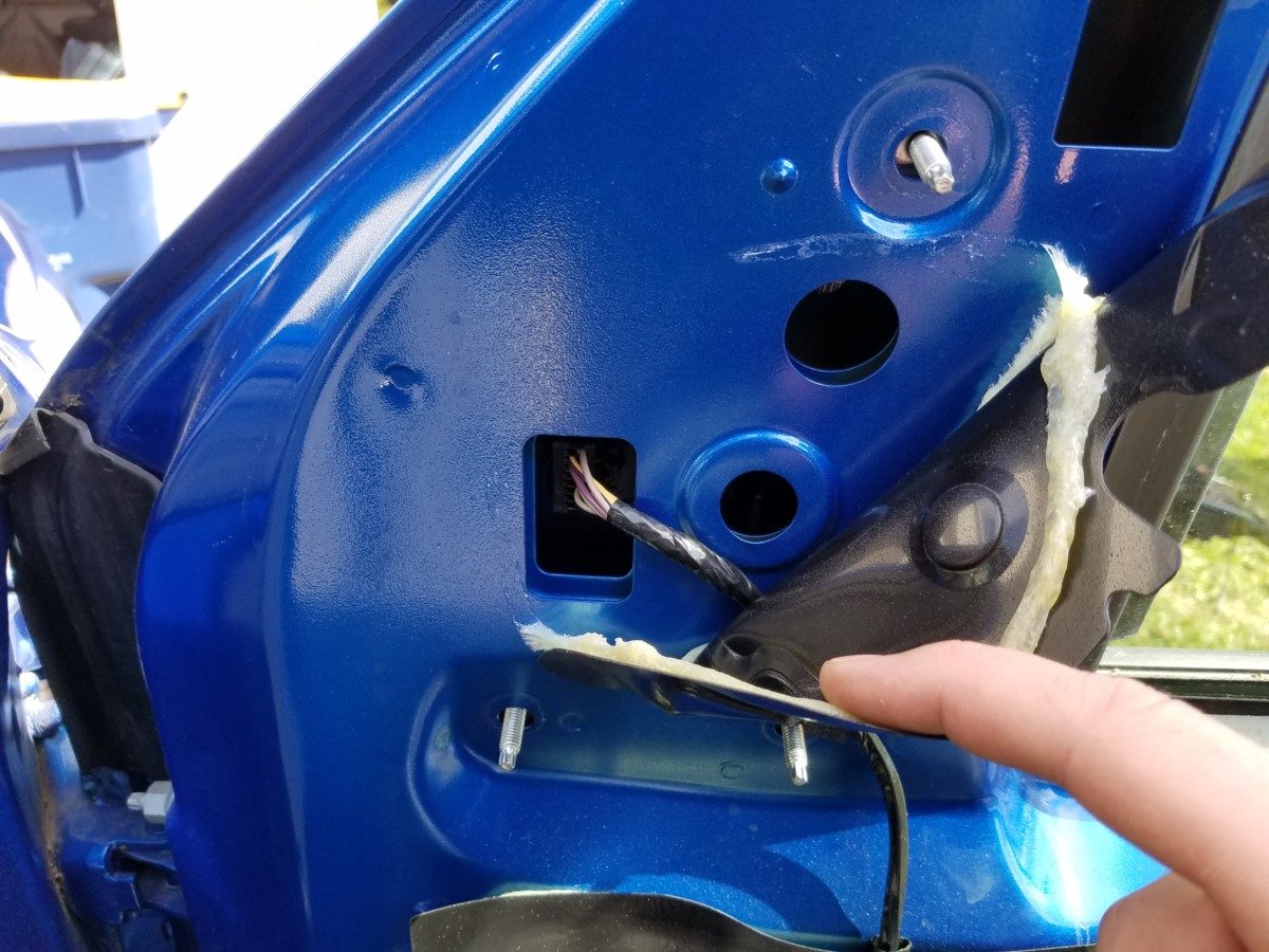 Peel back the rubber vapor barrier to expose the electrical plug, and disconnect. Remove the three nuts holding the mirror to the door. The mirror will NOT fall off or scratch any paint.