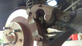 Lift the caliper up, it will pivot on the upper slider pin