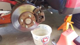 With a bucket ready, I'm just cracking the bolt loose