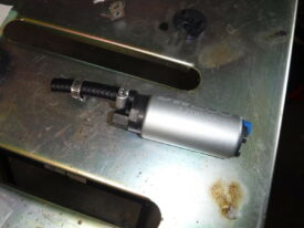 Remove smaller rubber cap and install fuel line and one clamp