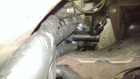 Loosen the line (above the bolts), then remove both bolts