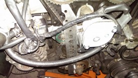 Crank bolt tool bolts to the plate, the other end smacks into the water pump.