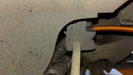 The fitting is horizontal behind this bracket