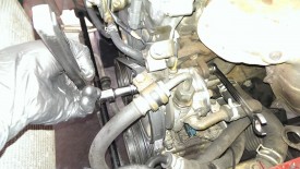 Rotate until you can get a wrench through the pulley to the mounting bolt