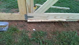 A piece of wood levels the gate and leaves an appropriate gap
